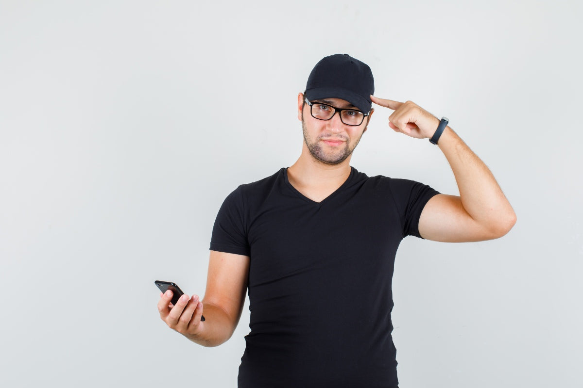 young man holding phone and pointing at cap